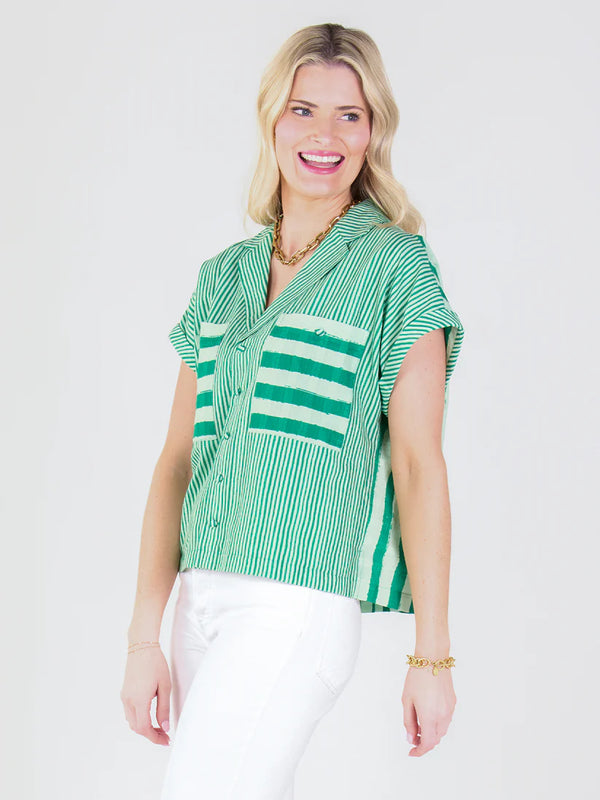Woman wearing a green and white striped shirt on a white background