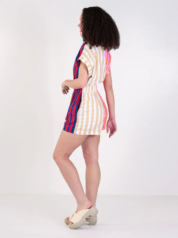 Woman wearing a colorful striped dress on a white background