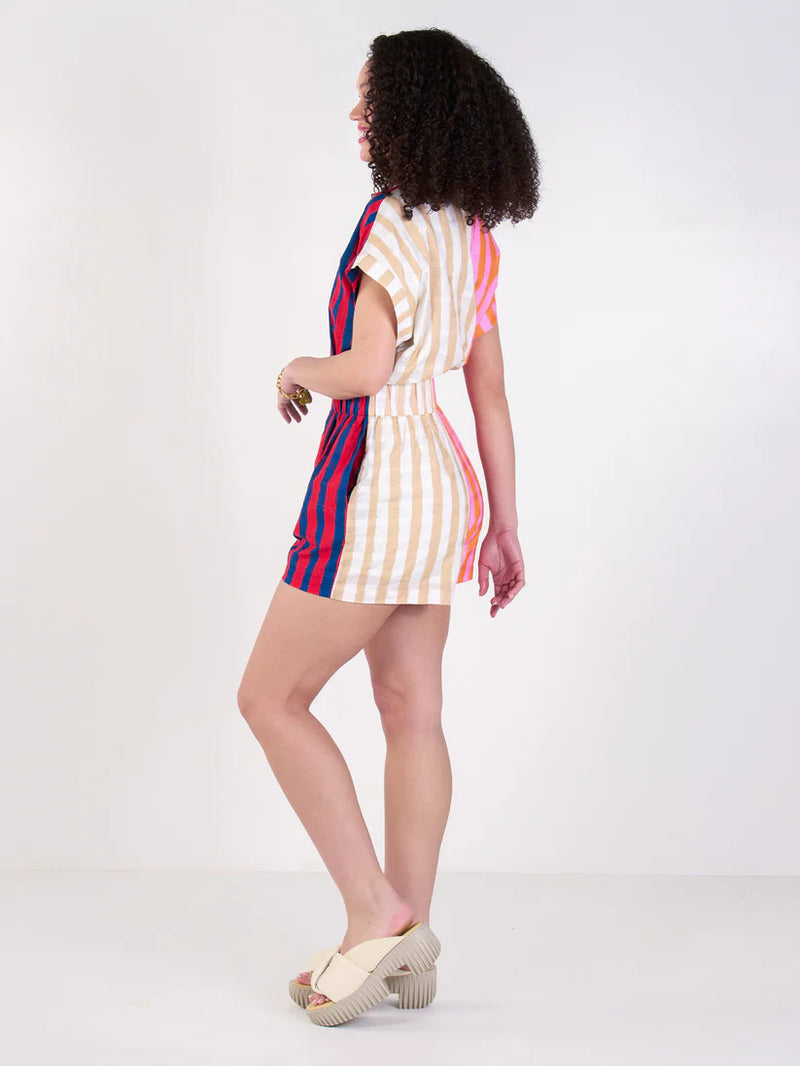 Woman wearing a colorful striped dress on a white background