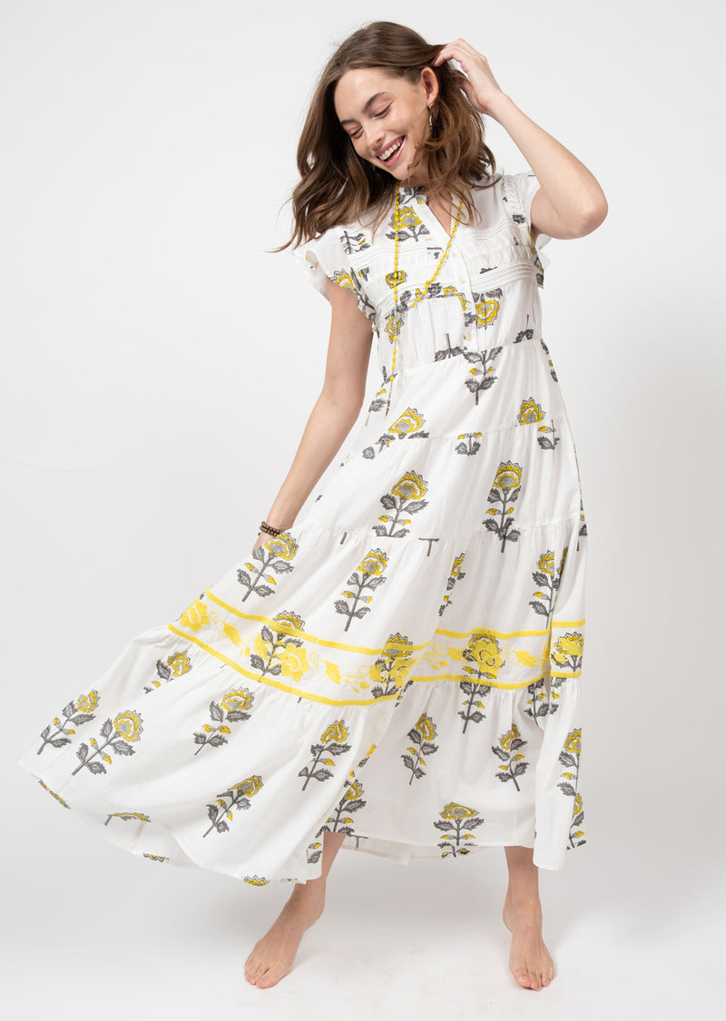 Woman wearing white maxi dress with yellow floral print all over