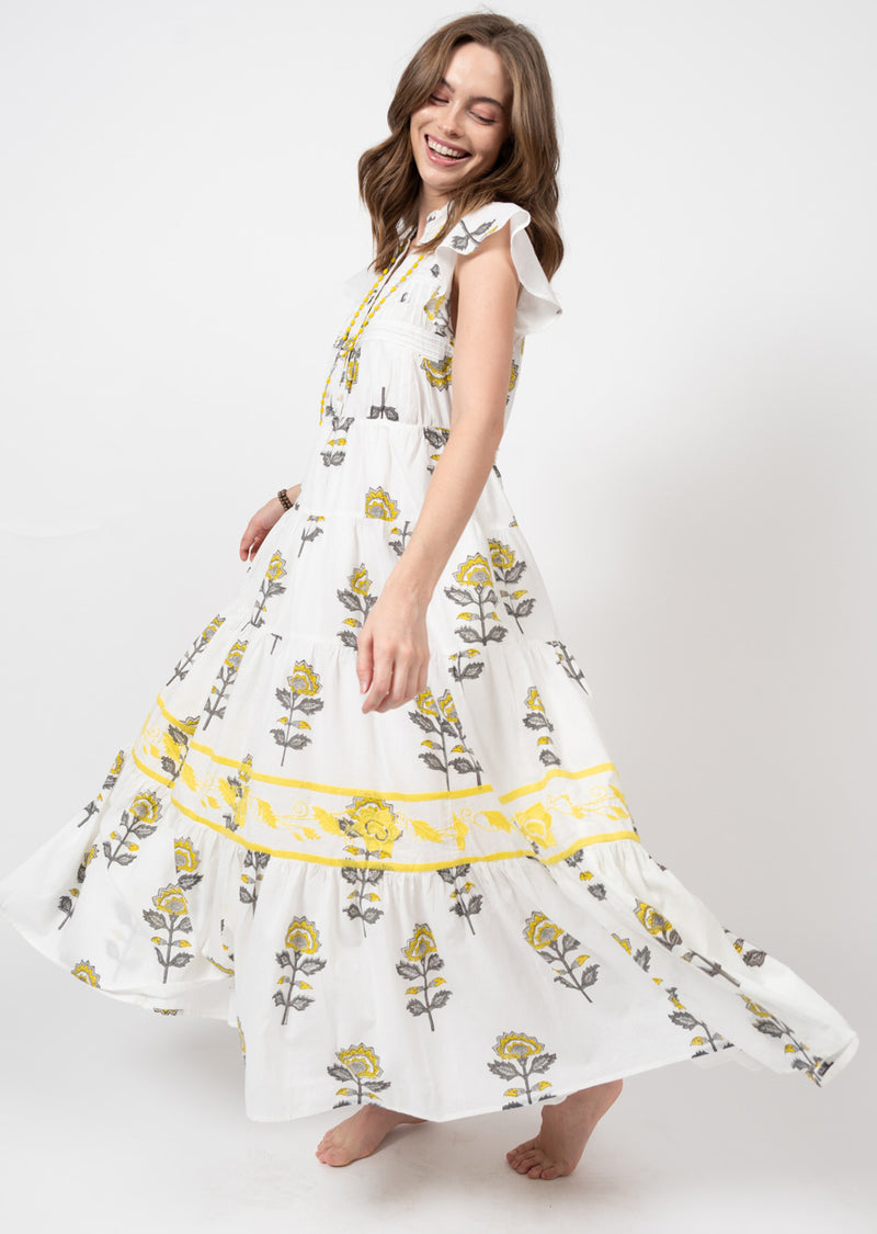 Woman wearing white maxi dress with yellow floral print all over