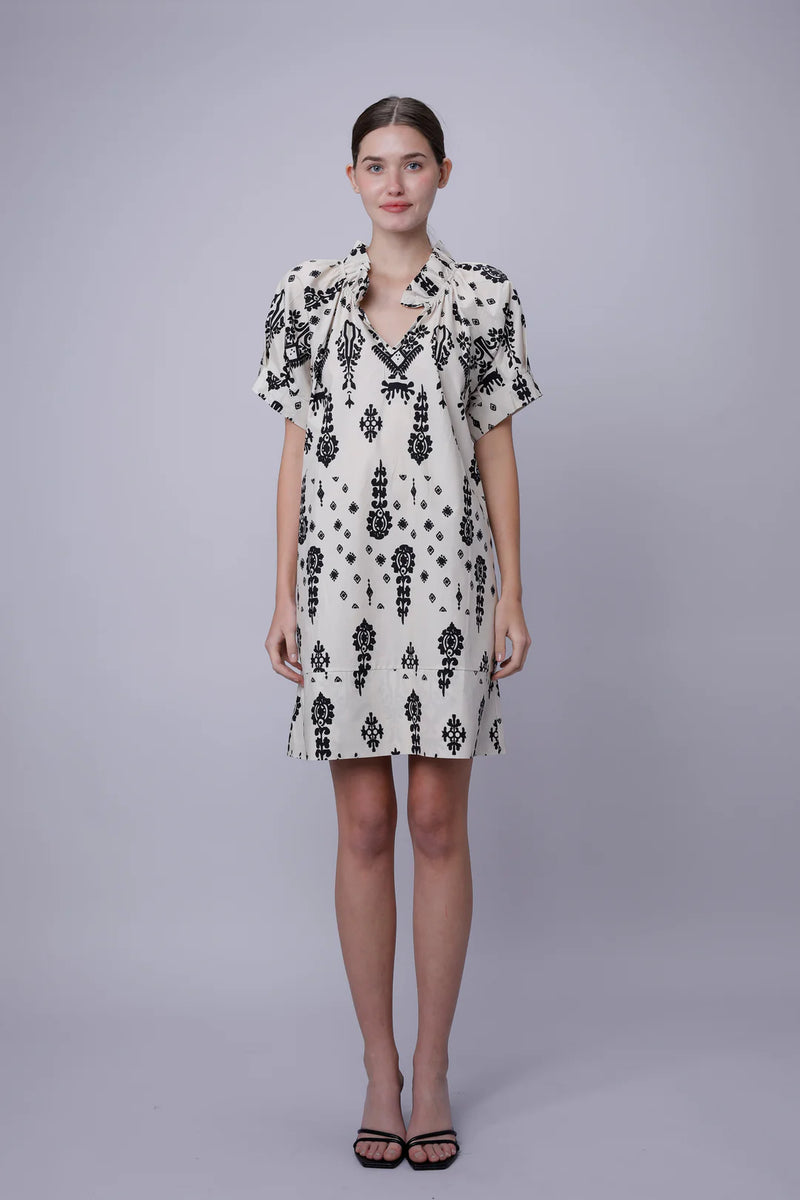 Woman wearing a black and white patterned dress on a gray background