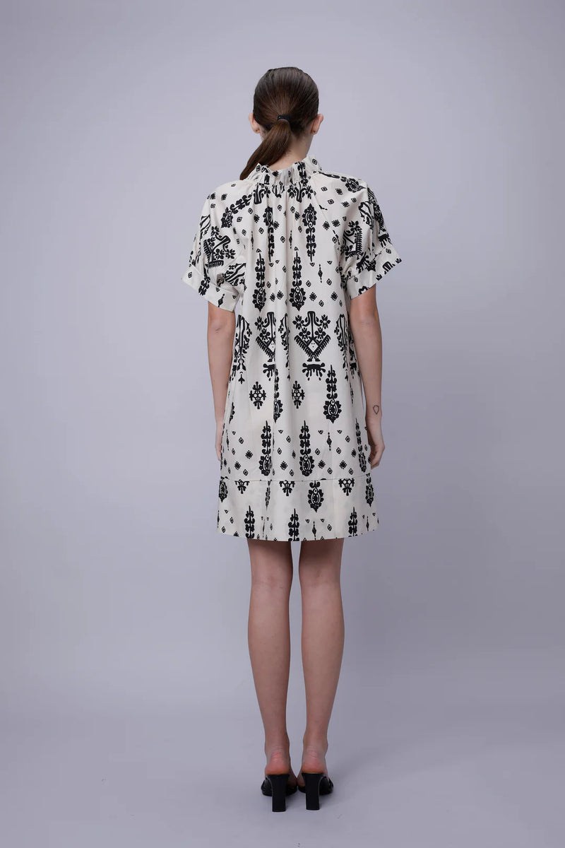Woman wearing a black and white patterned dress on a gray background