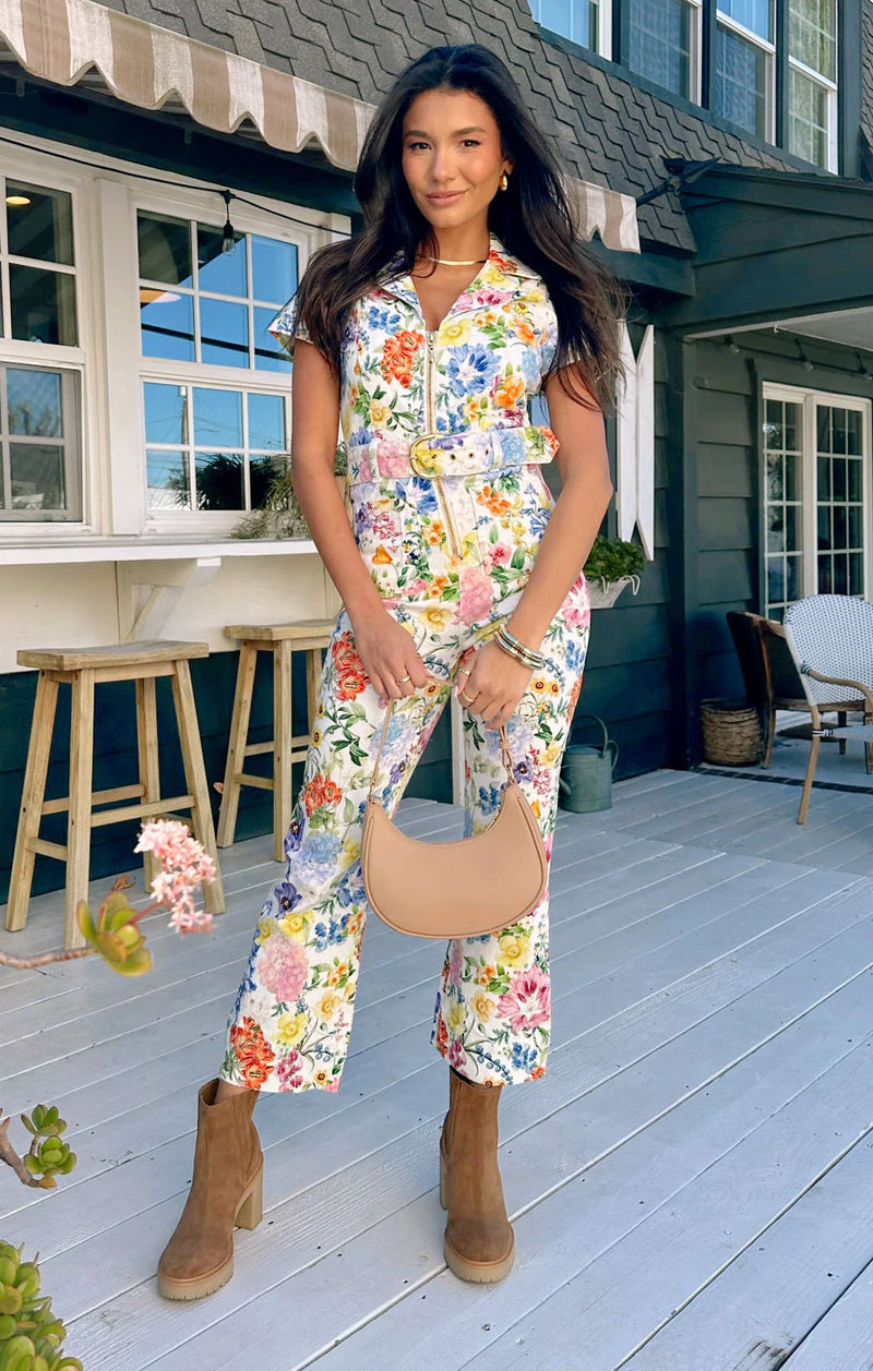 Woman wearing floral jumpsuit with matching belt