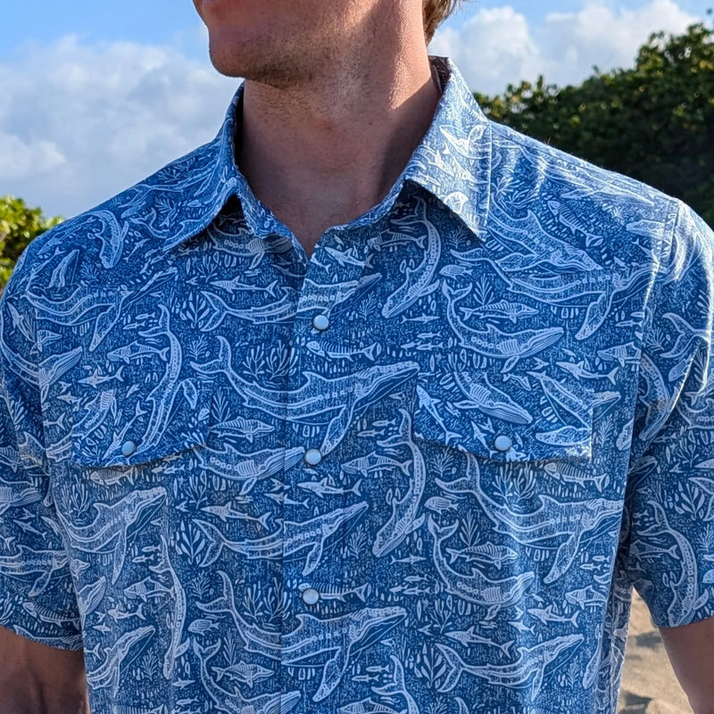 Man wearing a blue patterned shirt with a blurred background
