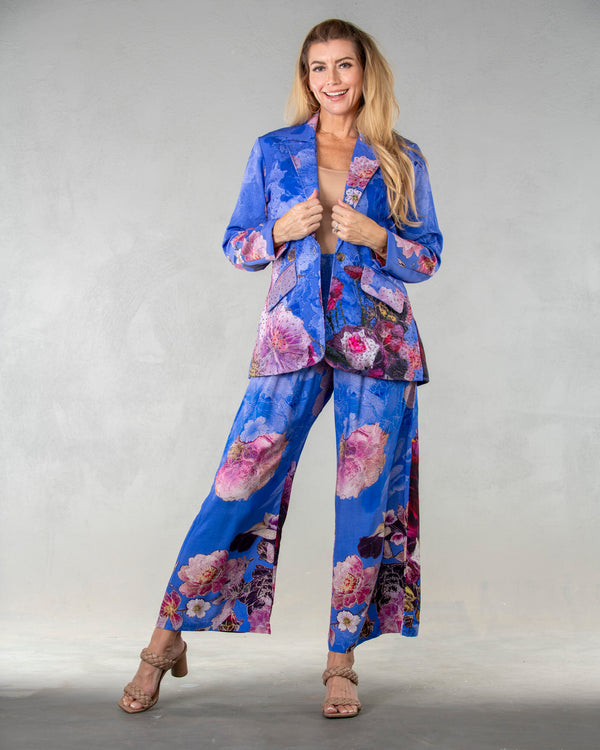 Woman wearing floral blazer with blue background and pink flowers