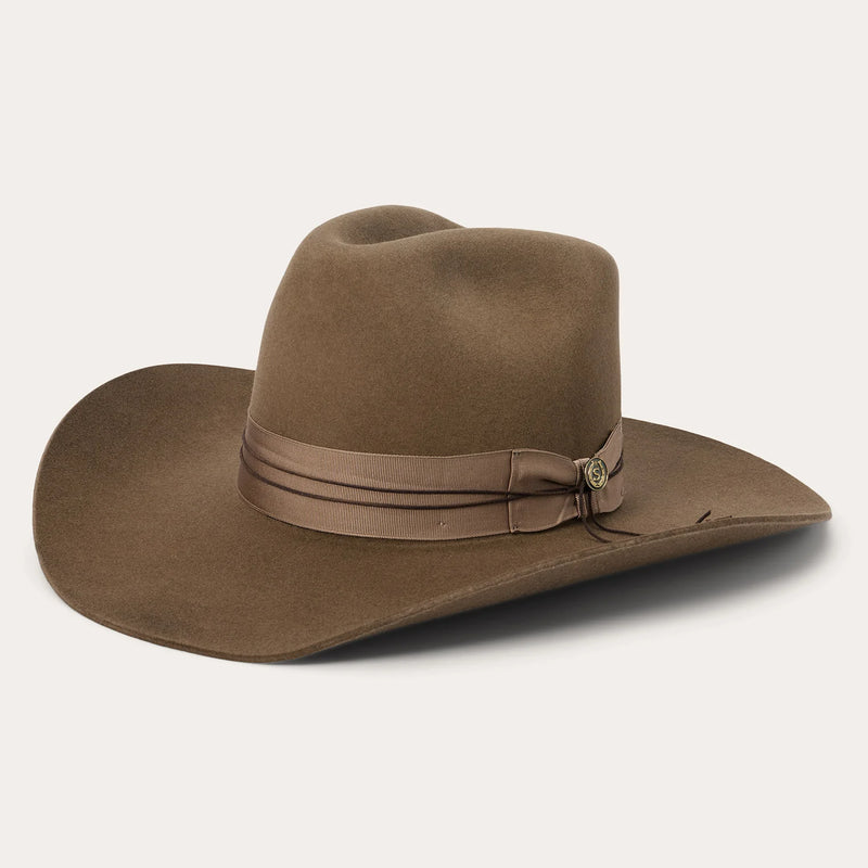 Brown cowboy hat with a band on a light gray background