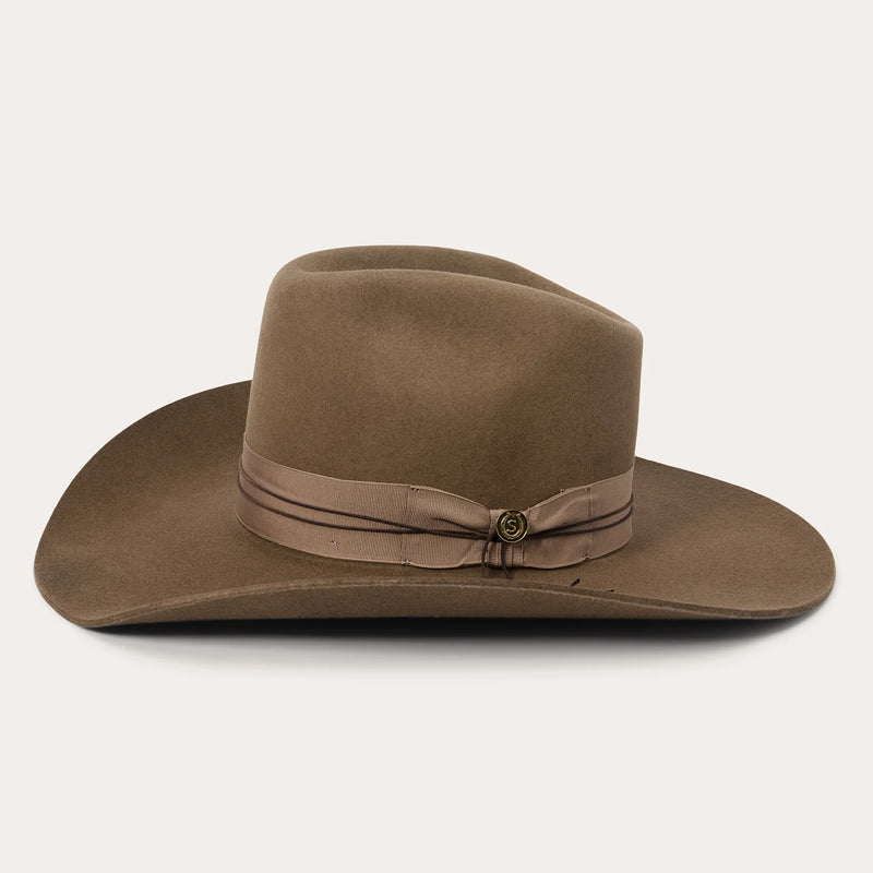 Brown cowboy hat with a band on a white background