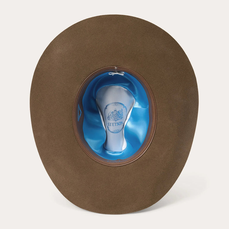 Brown Stetson hat with blue interior on a white background
