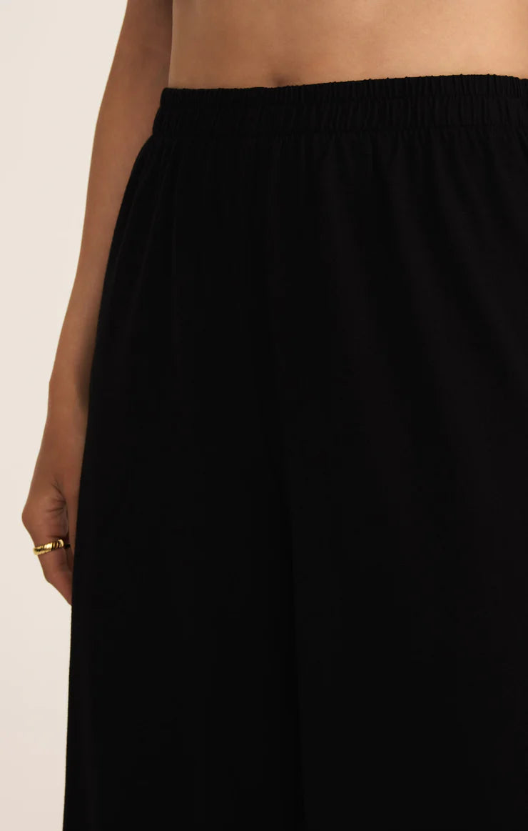 Black skirt worn by a person on a plain background