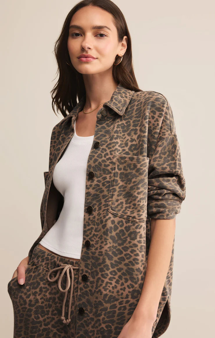 Woman wearing a leopard print jacket and pants on a beige background