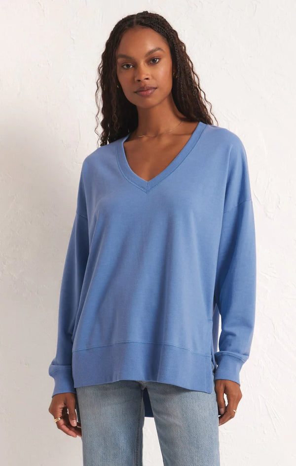 Woman wearing long sleeve, v-neck top with side slits.
