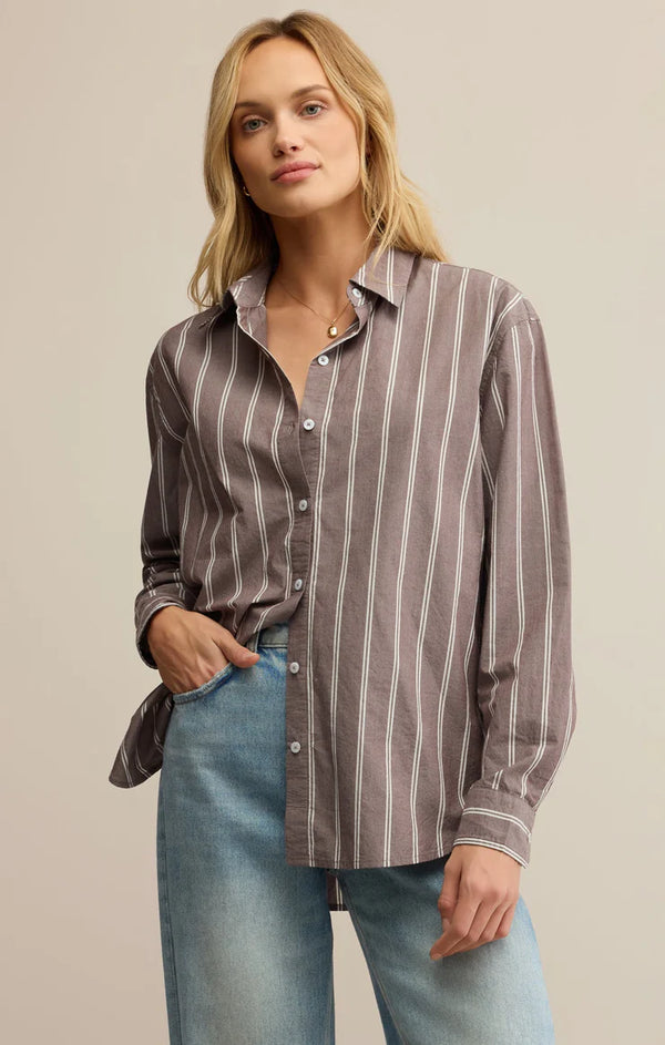 Woman wearing a striped shirt and jeans against a neutral background
