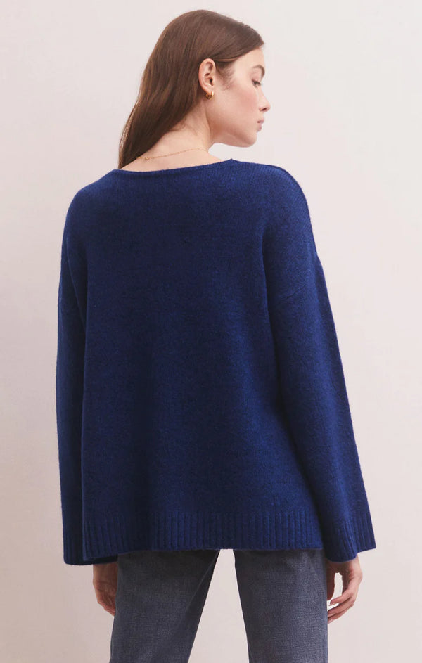 Woman wearing relaxed v neck sweater in a deep blue shade