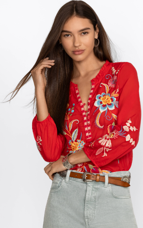 Woman wearing red blouse with long sleeve, button detail and floral embroidery in multicolor 