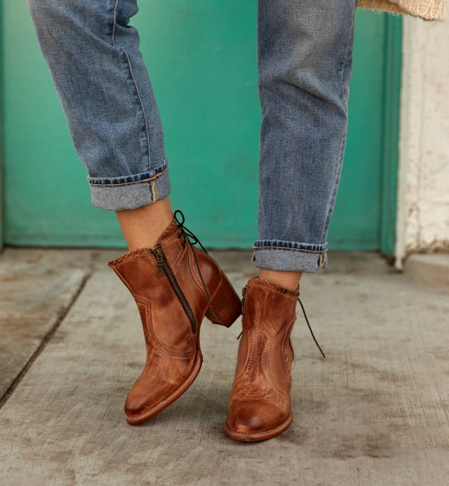  lady in jeans wearing a tan leather bootie 