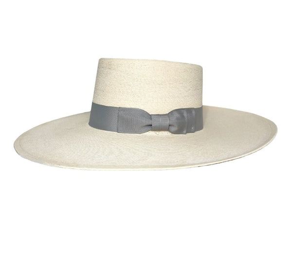 The Buckaroo Hat is extra special with the wide silver grosgrain ribbon hat band. The woven Western hat has a wide flat brim that is slightly turned up in back.