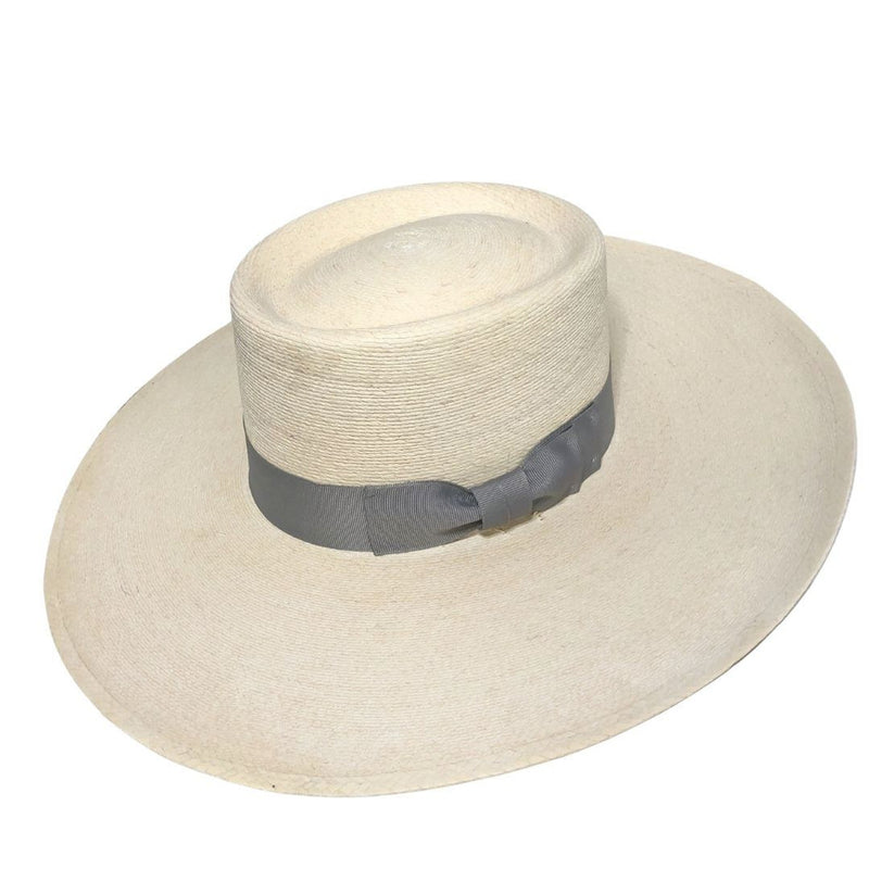 The Buckaroo Hat is extra special with the wide silver grosgrain ribbon hat band. The woven Western hat has a wide flat brim that is slightly turned up in back.