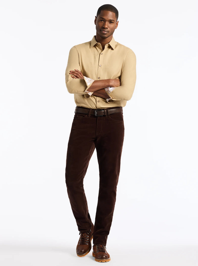 Man wearing a beige shirt and brown pants on a white background