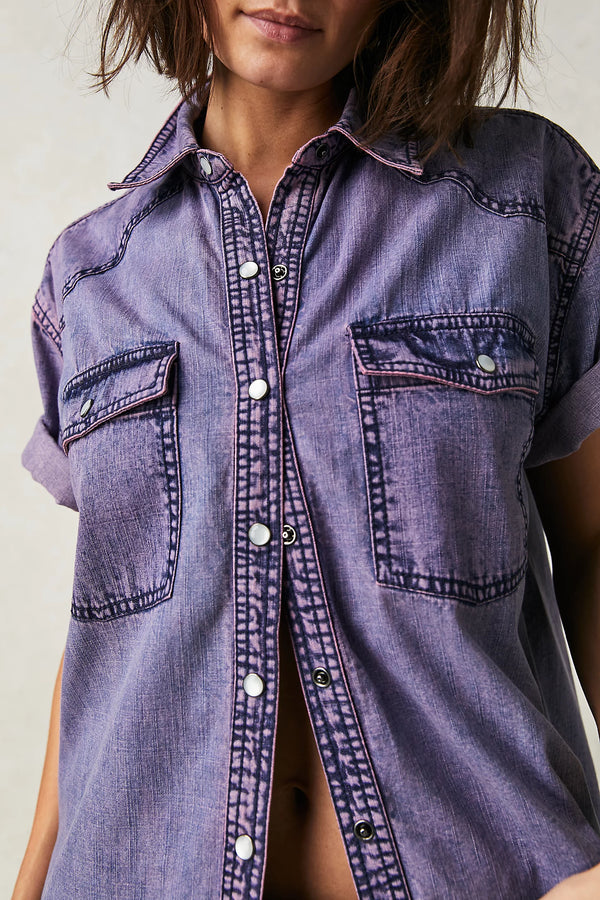 Woman wearing purple denim button up with double breast pockets and a collar