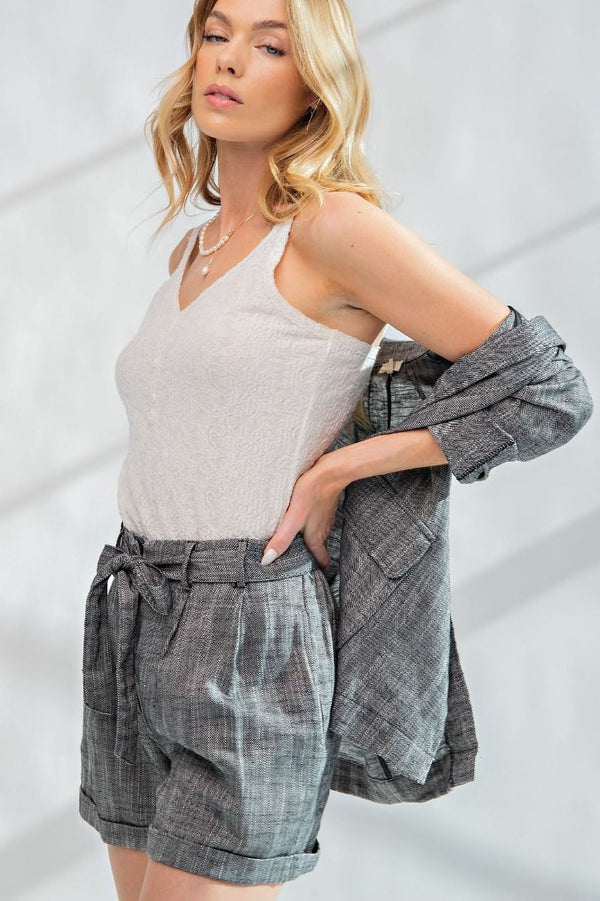 Woman wearing tie waist shorts in a black and white woven fabric