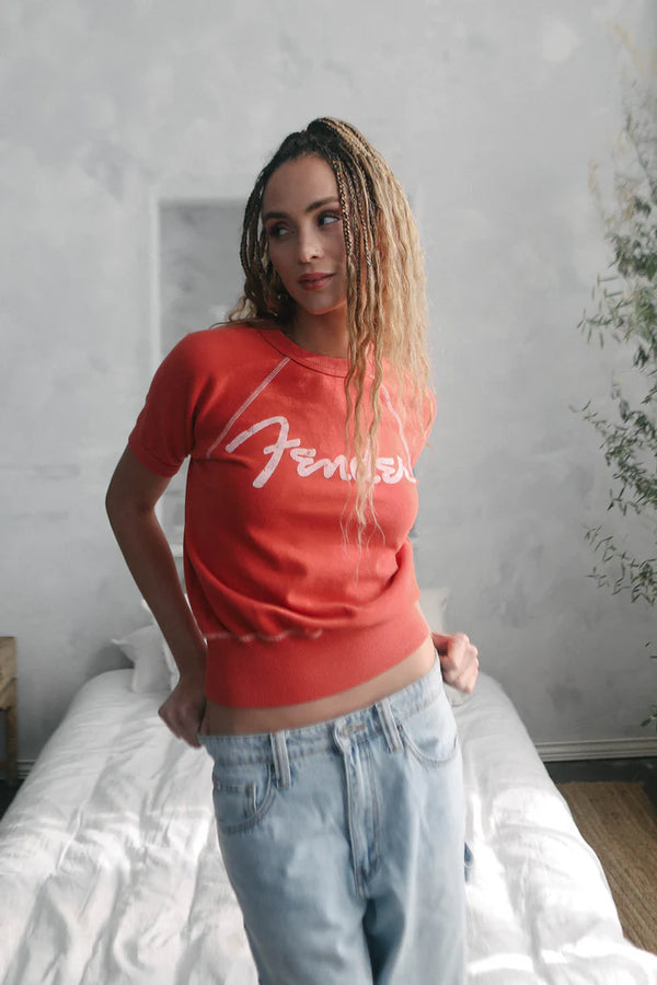 Woman wearing short sleeve shirt with "Fender" written on the front