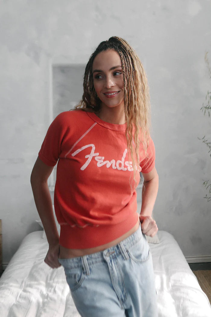 Woman wearing short sleeve shirt with "Fender" written on the front