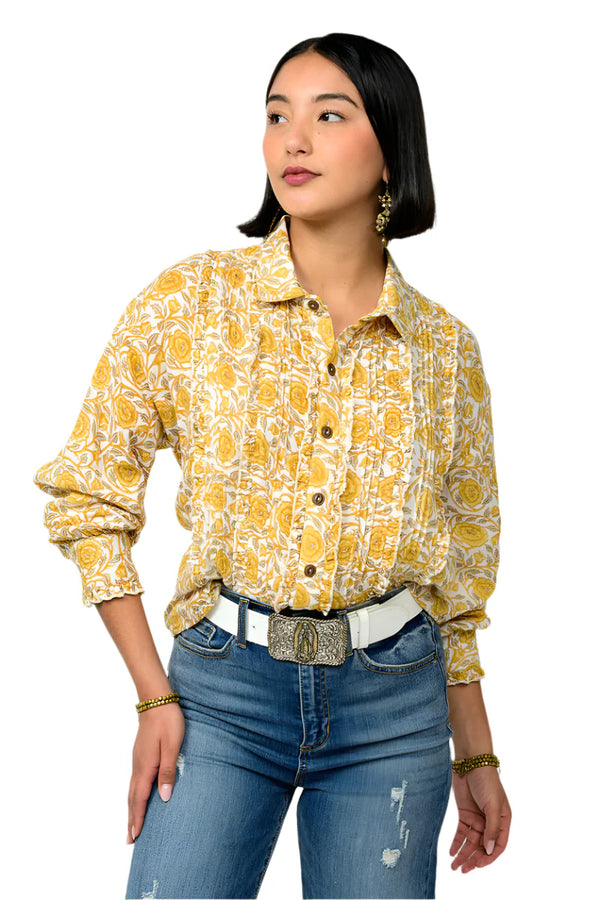 Woman wearing a yellow floral blouse and blue jeans on a white background