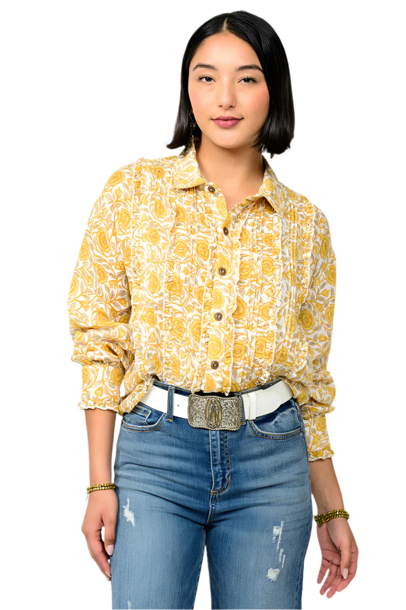 Woman wearing a yellow floral blouse and blue jeans on a white background