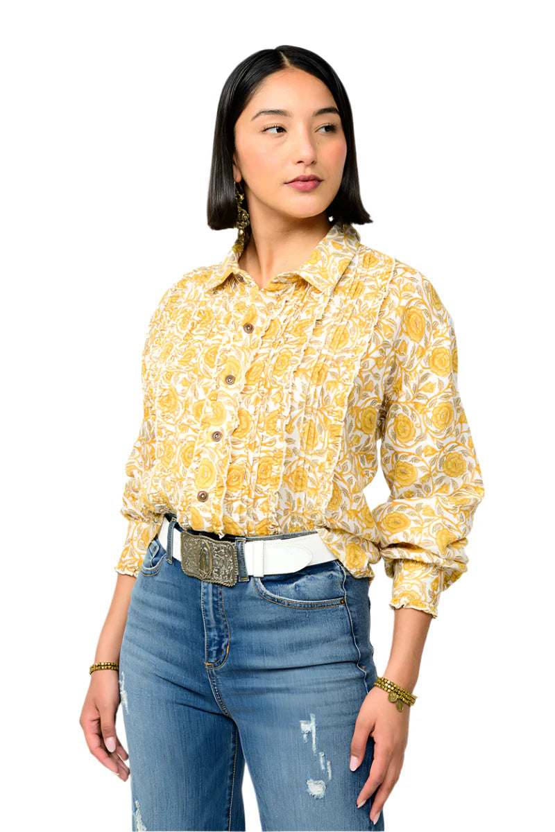 Woman wearing a yellow floral blouse and blue jeans on a white background