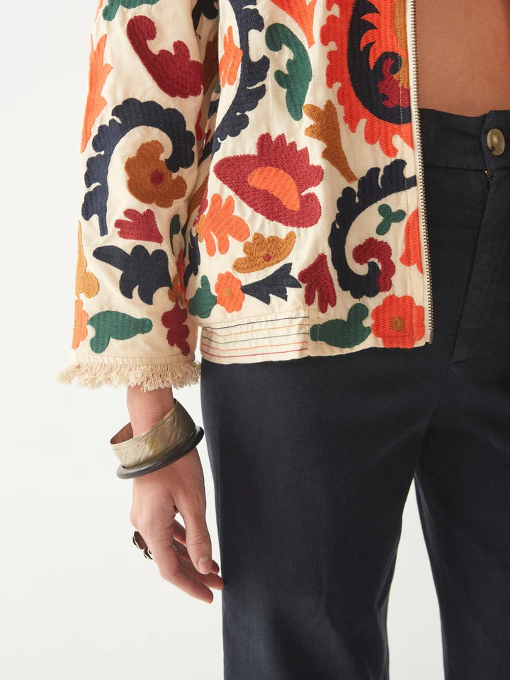 Woman wearing floral embroidered jacket in jewel tones and long sleeves
