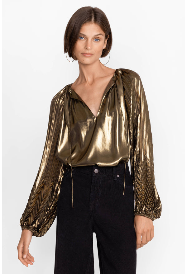 WOMAN WEARING METALLIC GOLD LONG SLEEVE TOP WITH V NECK AND STRINGS WITH DETAILS ON SLEEVES
