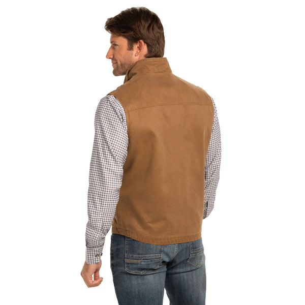 Man wearing a brown vest over a checkered shirt on a white background