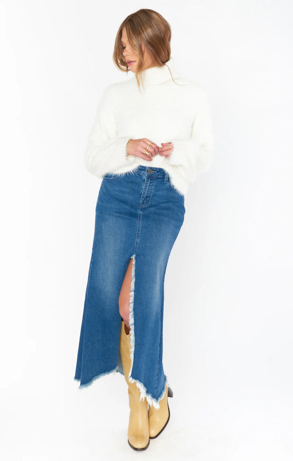 Woman wearing denim maxi skirt with fuzzy white sweater and fall boots