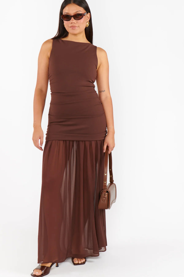 Woman wearing a brown sleeveless dress with a white background