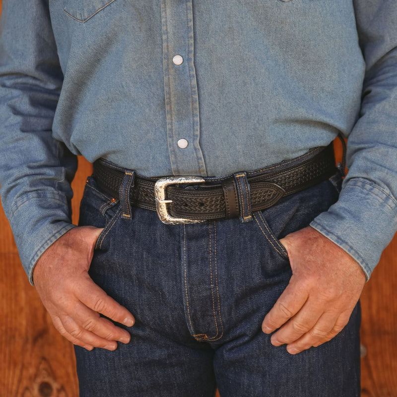 Person wearing a blue denim shirt and dark jeans with a black belt.
