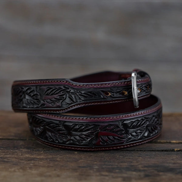 Decorative leather belt with intricate designs on a wooden surface