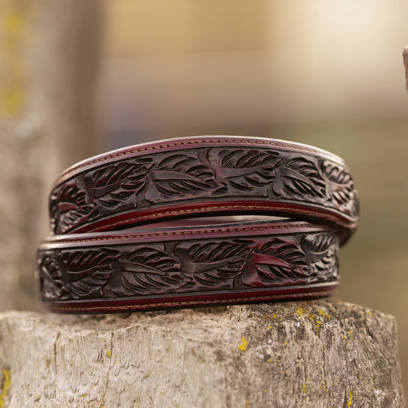 Decorative leather belt with intricate patterns on a wooden surface