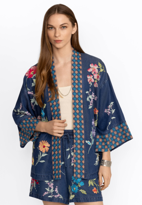 Woman wearing tensile kimono with floral embroidery all over with geometric pattern around the cuffs and neckline