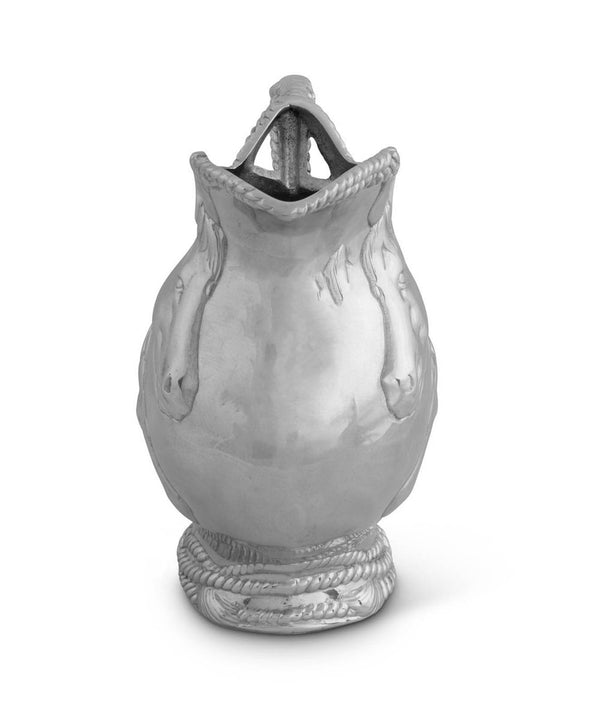 Metal pitcher with rope detail and two horse faces on the side